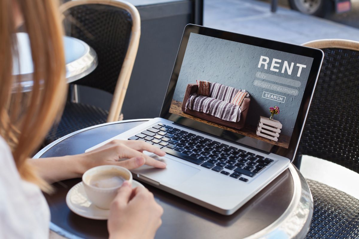 The image shows a girl using a laptop while having a coffee referring to renting out extra space online can be an easy way to make money without much work.