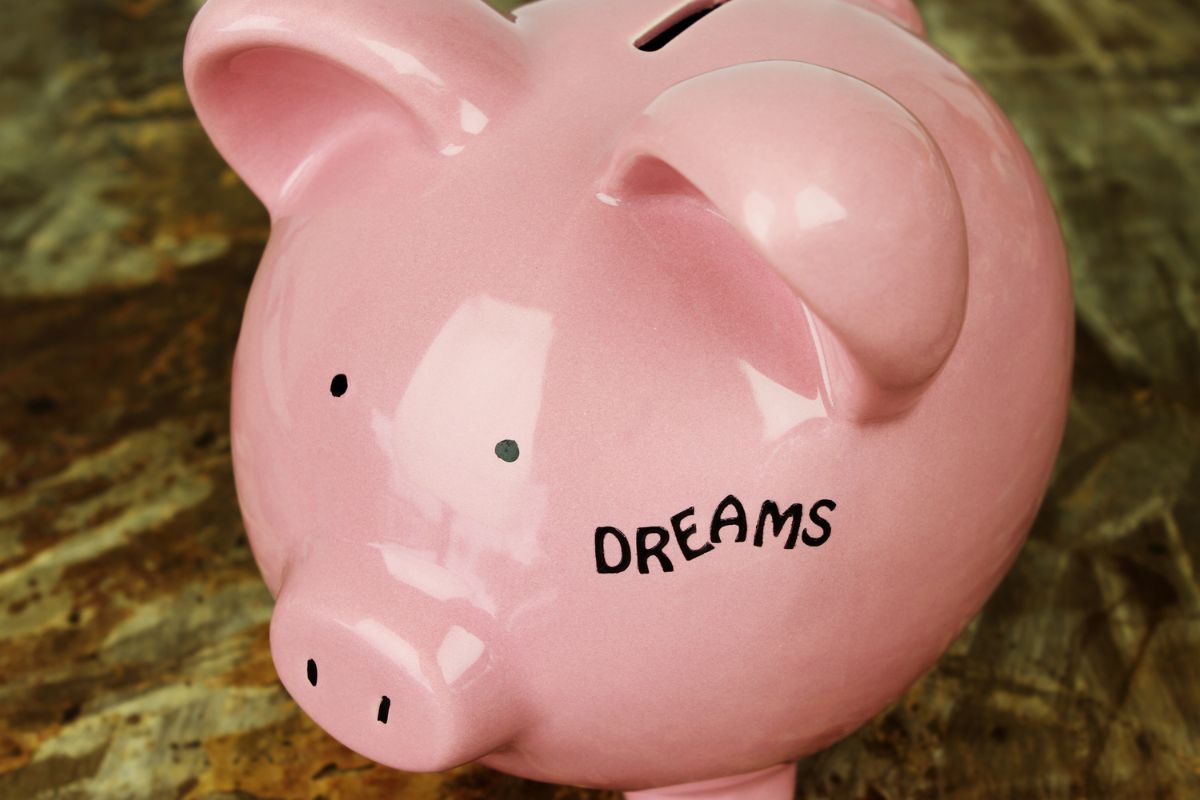 The photo tells about a piggy bank with a note which means to label savings accounts with specific goals that help give your savings a purpose and make it easier to stick to your goals.