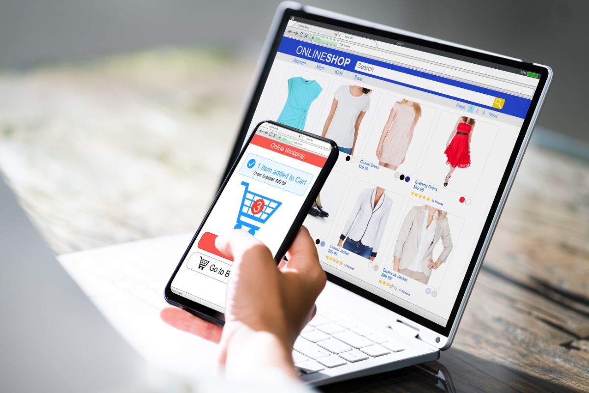 The photo shows a laptop with a screen display and a girl's hand using a phone referring to removing the saved payments method from the online store makes it easier to stick to your no-spend rules.