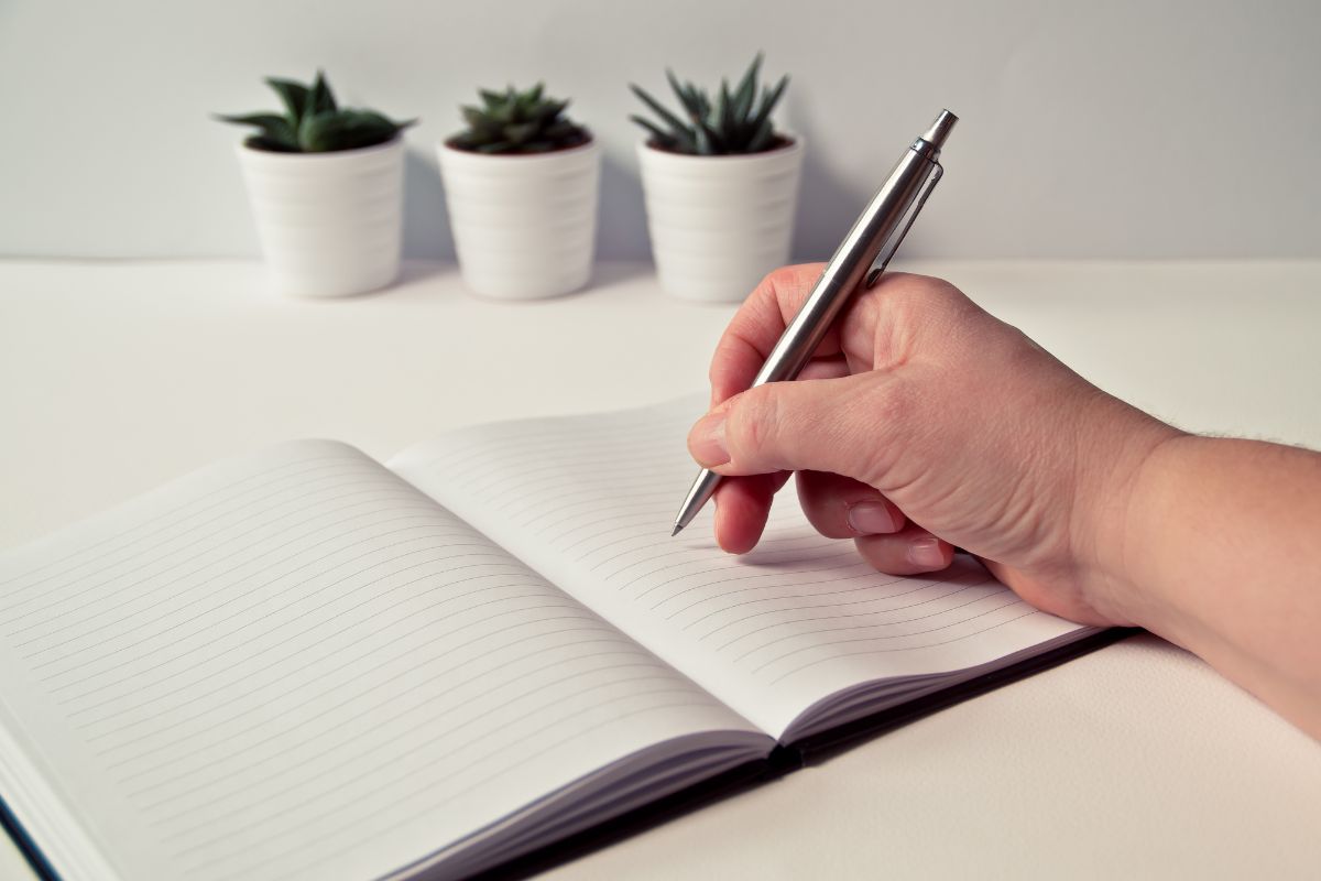 The photo tells about plants and a girl's hand and writing on the notebook indicating to set clear spending rules to keep the challenge focused and easier to follow.