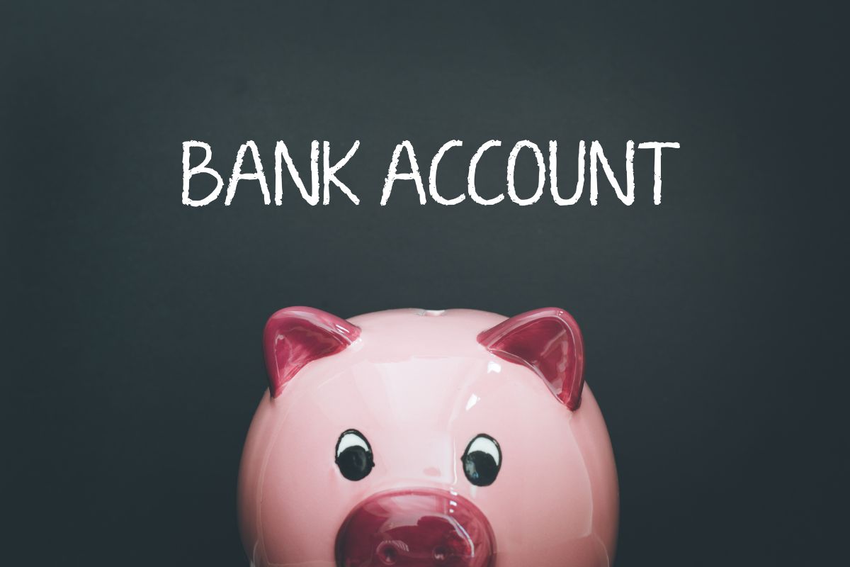 The picture shows a piggy bank and a note on the board which means to rename your bank accounts based on priorities making it easier to budget and meet financial goals.