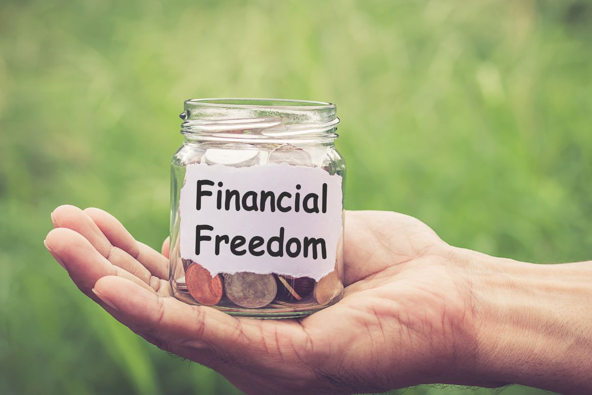 The image tells about a man's hand holding a jar filled with coins with a note referring to why financial freedom matters, which means having control over your money instead of letting it control you.