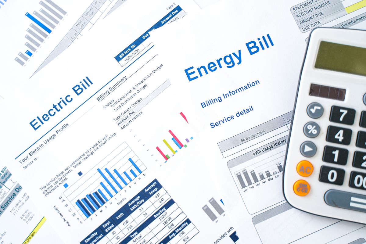 The picture shows a calculator and papers with notes indicating that negotiating bills and subscriptions help free up extra cash that can add to savings or investments.