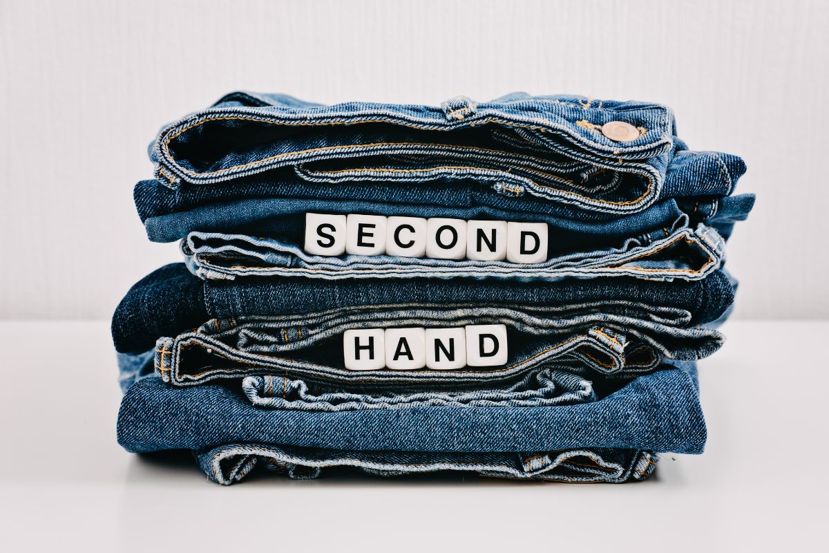 The image shows jeans with notes indicating to shop secondhand can save a lot of money and put toward financial security.