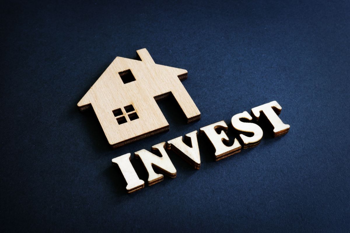 The photo tells about a wooden mini house and letters referring to investing early is one of the best ways to achieve financial independence.