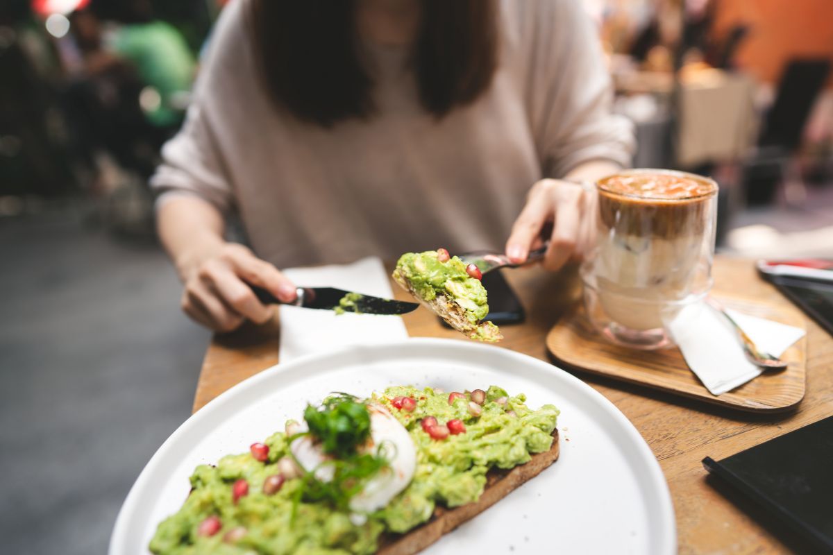 The photo tells about food on the plate, a drink on the glass, and a girl slicing the food referring to target fun spending to cut first making it easier to stick to the challenge.  