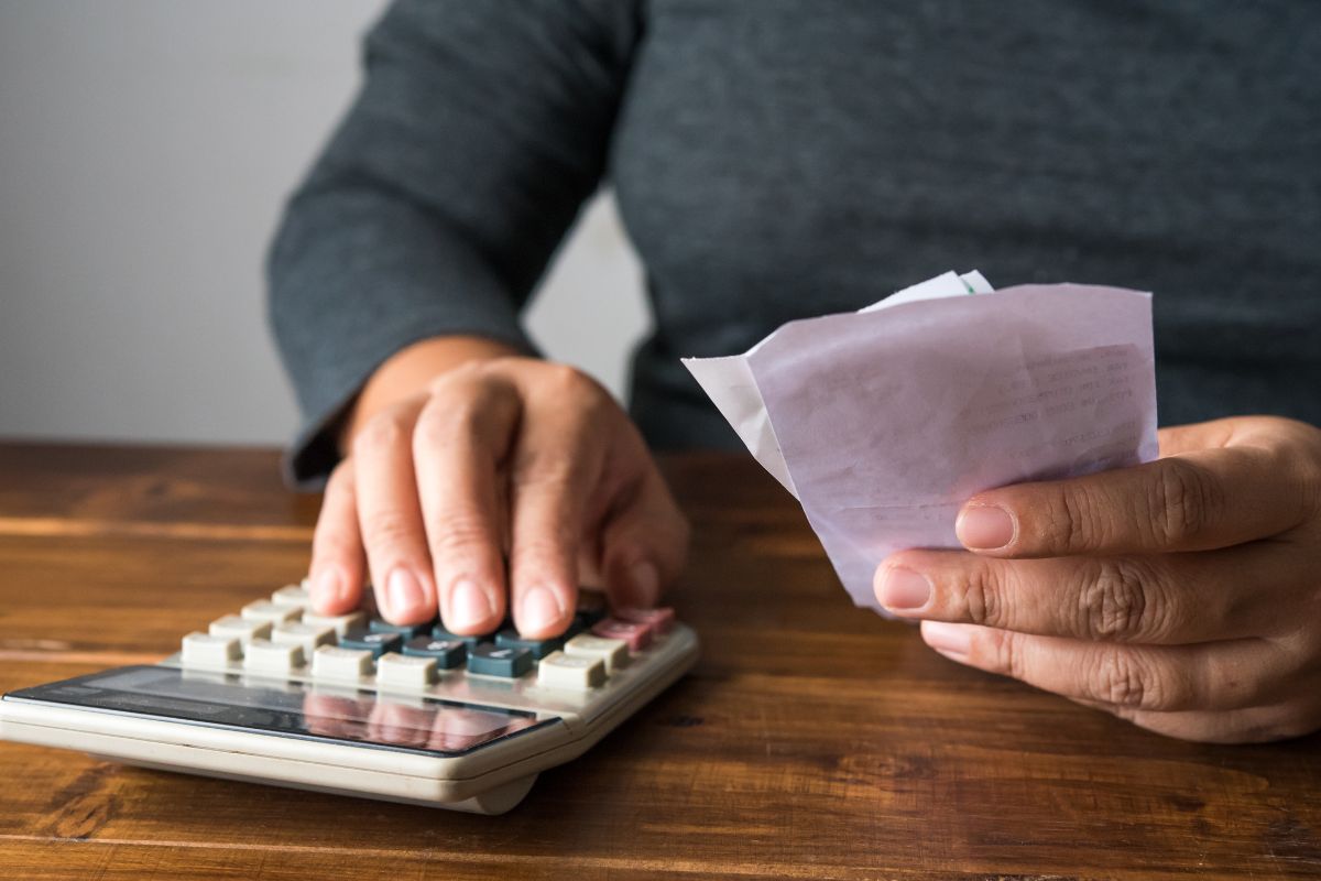 An image shows a woman tracking her expenses.