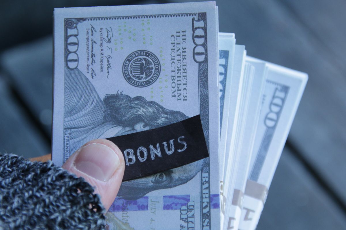 The photo shows a woman's hand holding a money bonus.