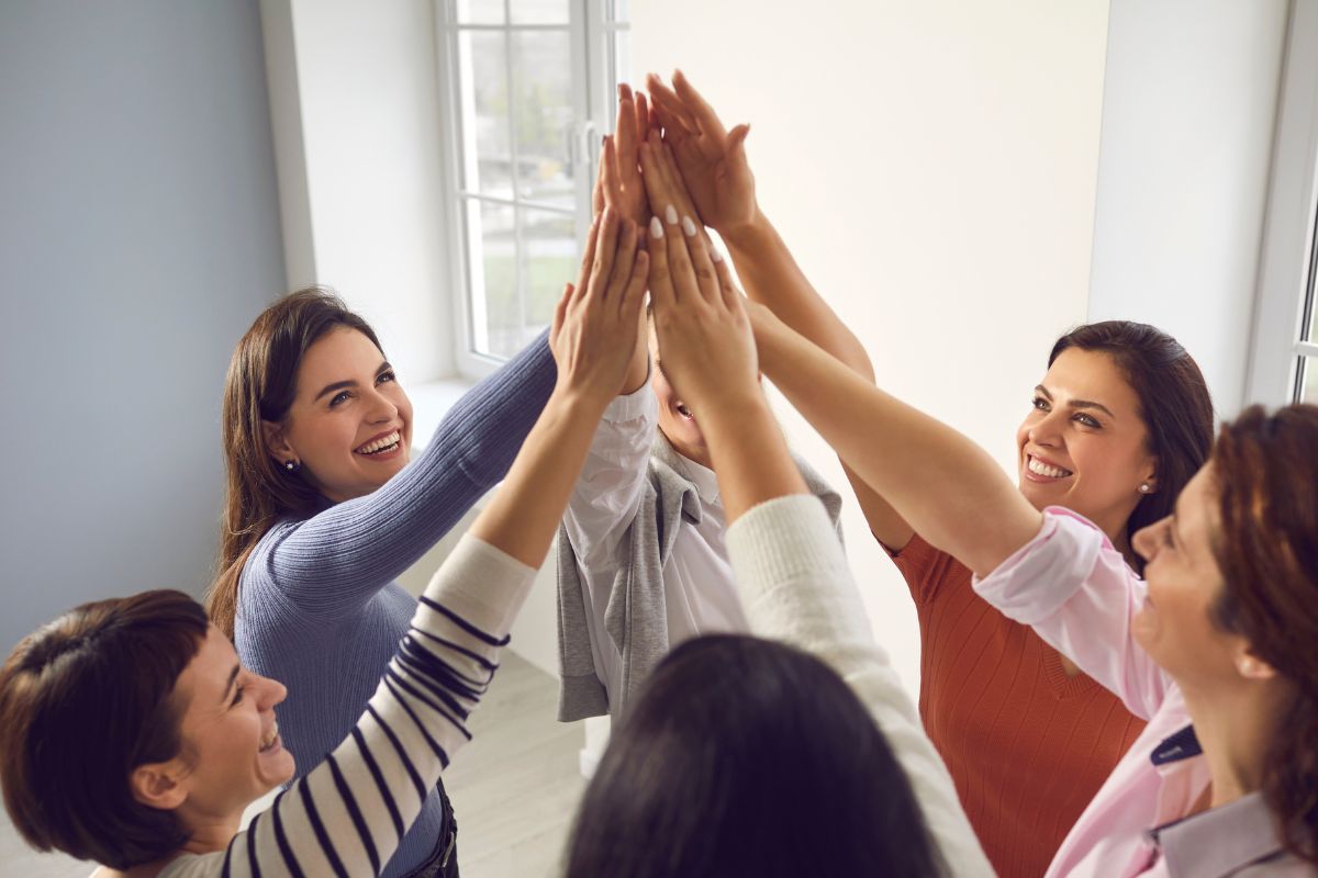 The image shows a group of women uniting.