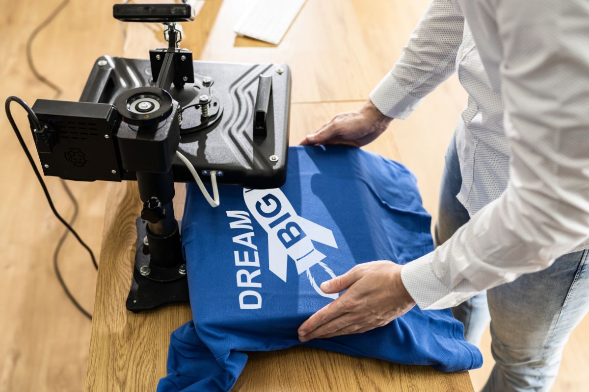 The image shows a man printing a shirt.