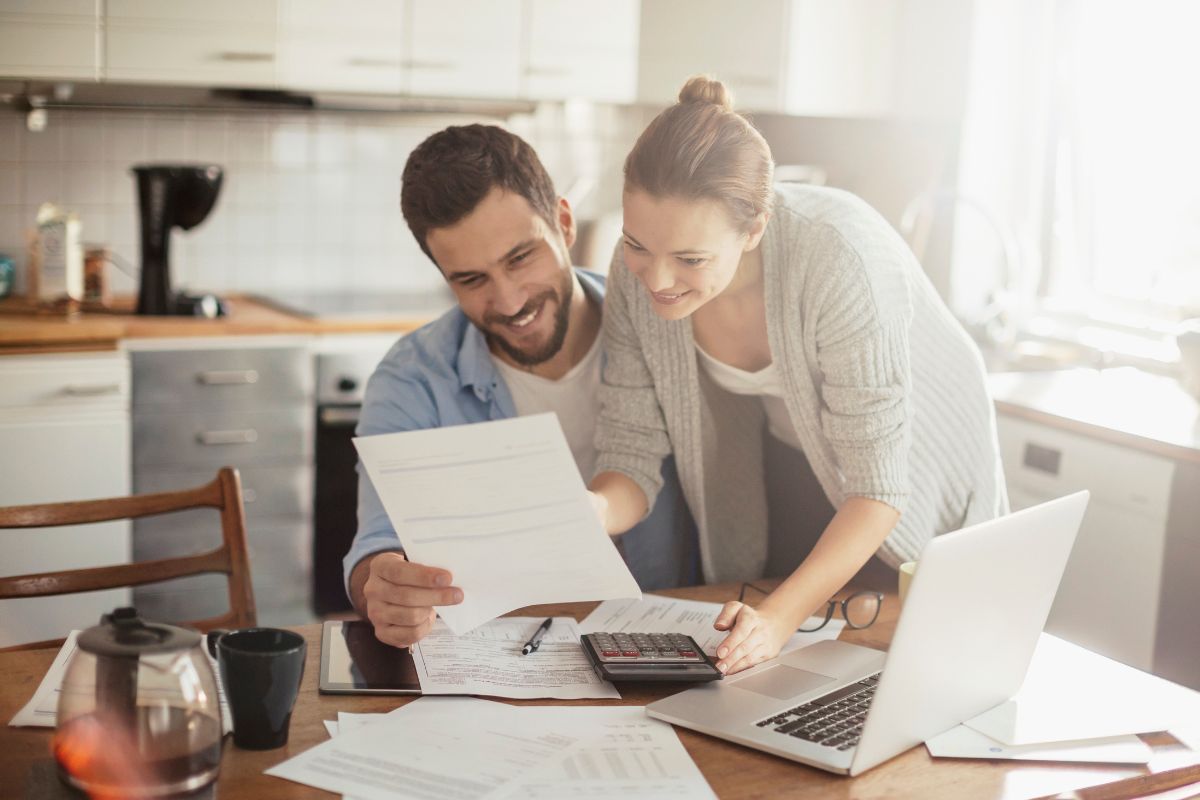 The photo shows a couple budgeting.