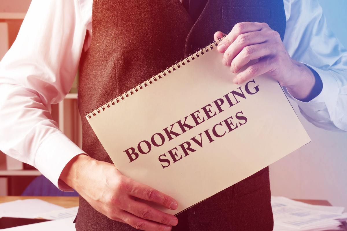 A man holding a notebook with bookkeeping services wording.