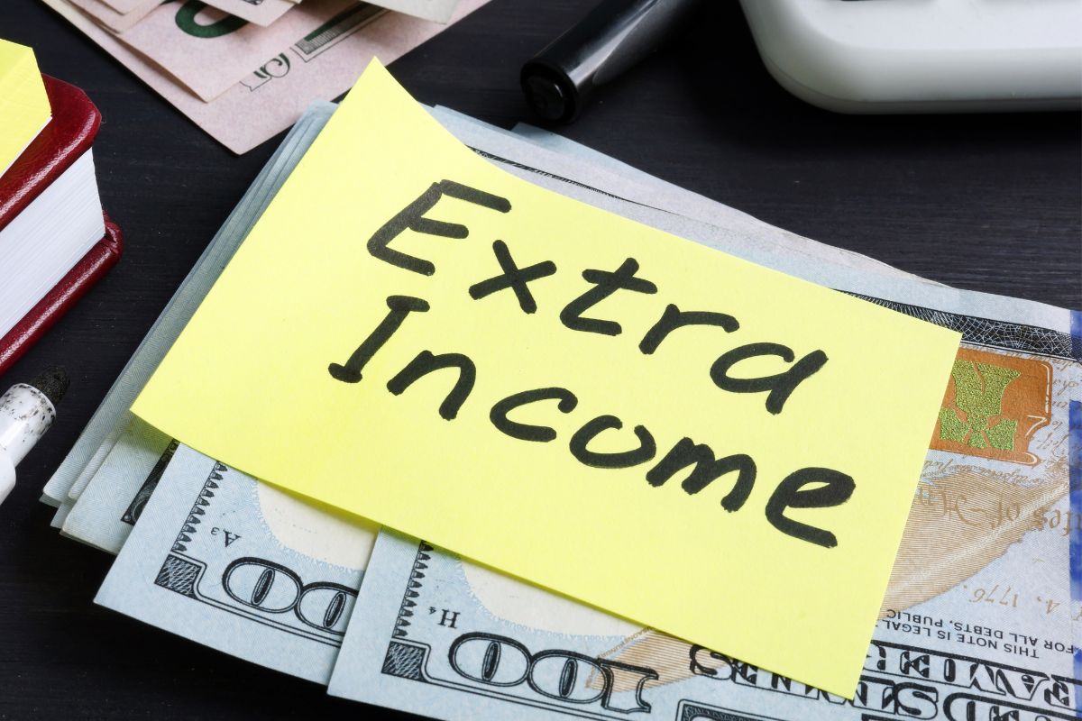 Image of money and a paper with extra income wording.