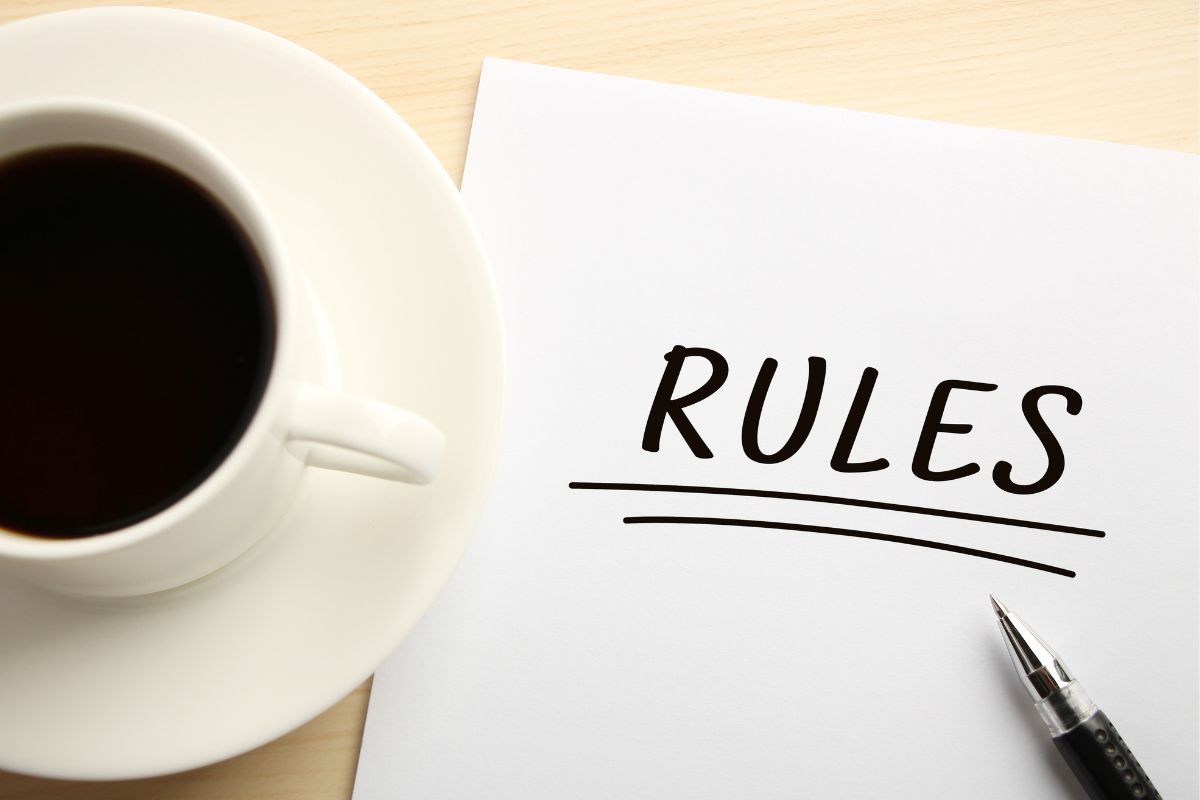 A picture of a coffee and a notebook with the rules wording.