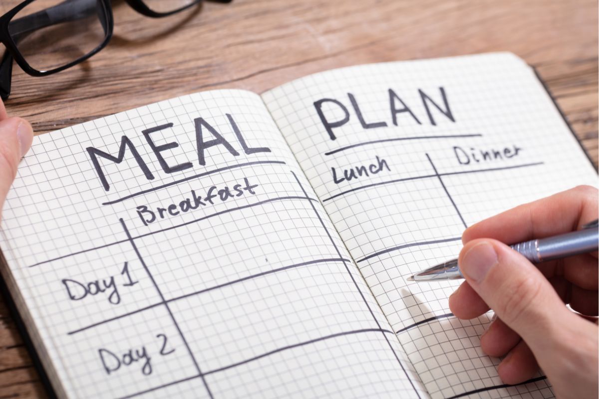 Image of a man's hand making a meal plan.