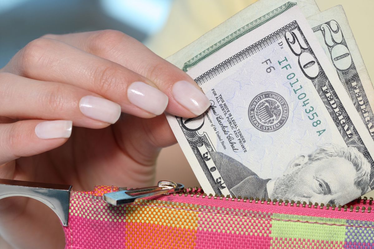 The photo shows a woman's hand showing her money.