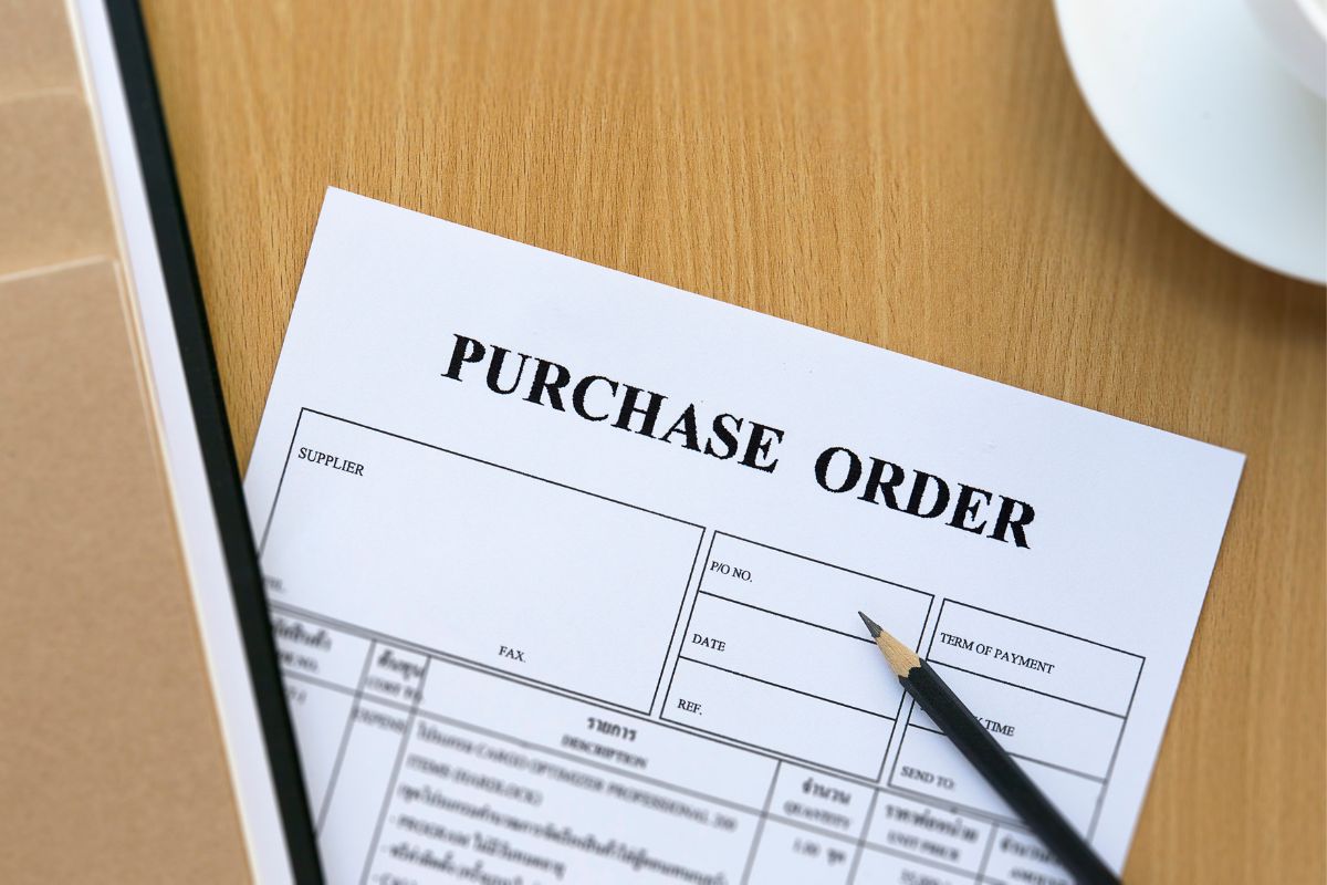 The photo of a pen and a purchase order form.