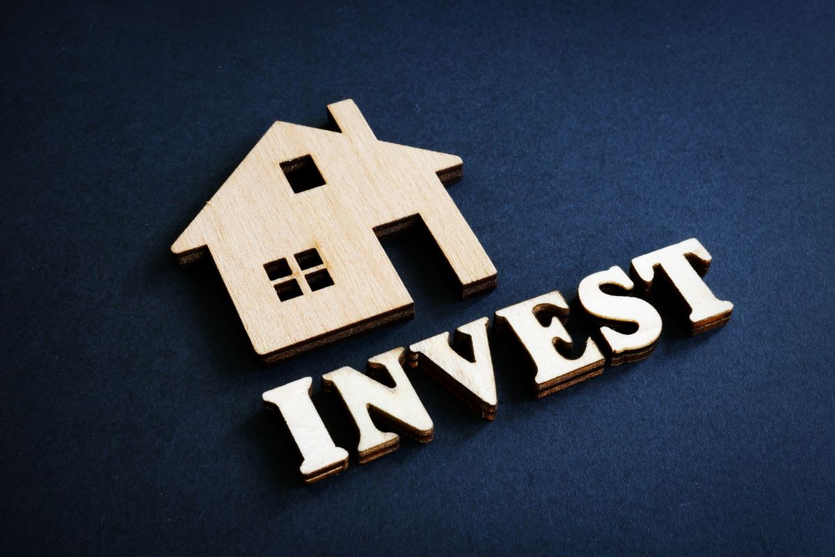 The photo shows a house and invest wording.