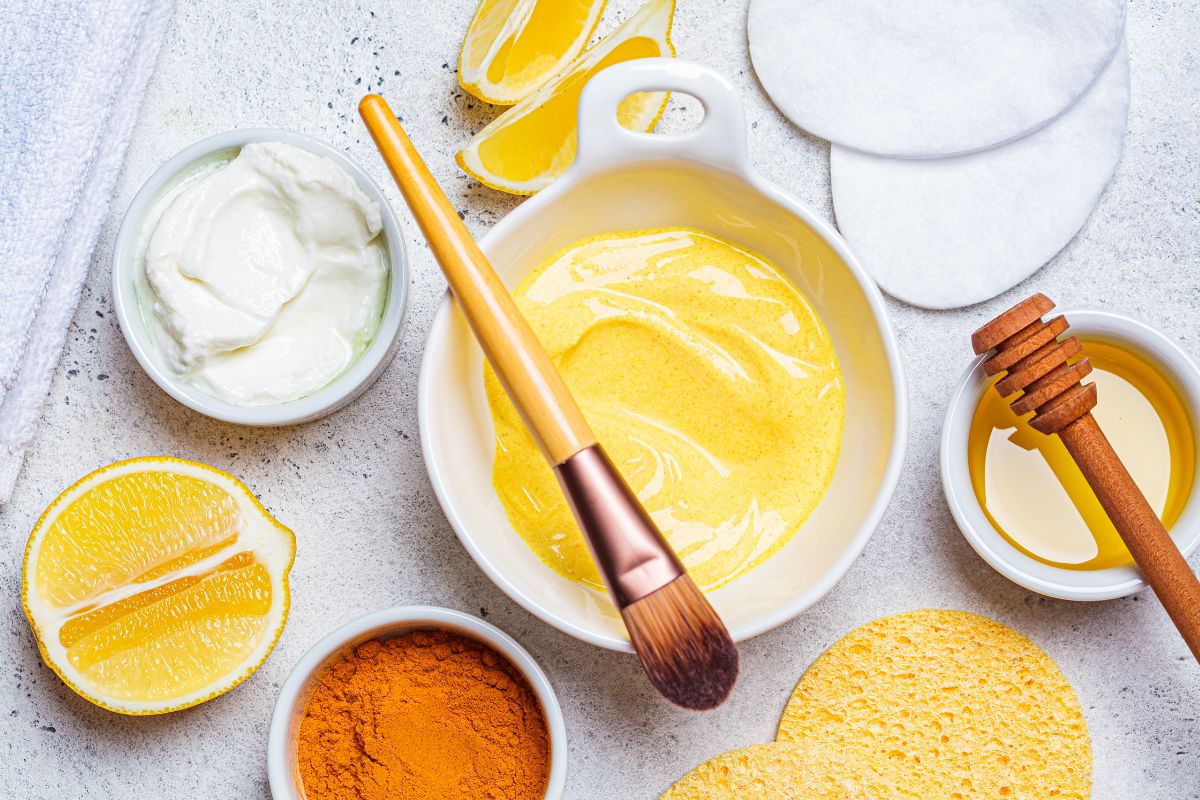 The image shows honey, turmeric powder, a lemon, and other ingredients indicating that trying a DIY spa day is a relaxing way to unwind while keeping your wallet closed.