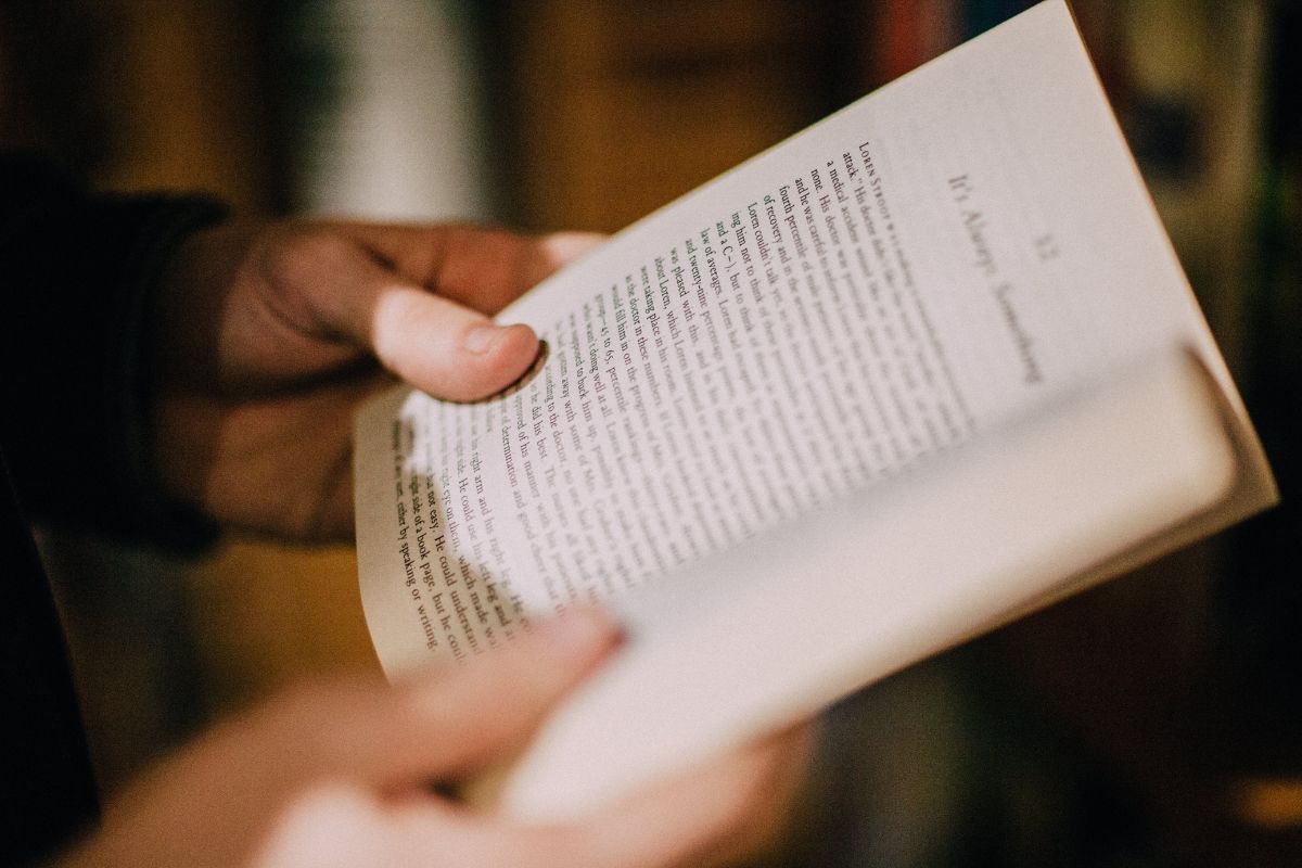 Photo of a woman's hand reading a book.