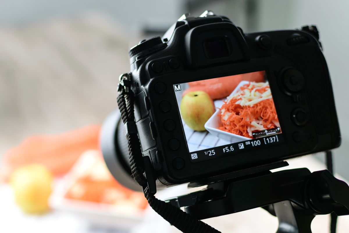 The photo shows a camera taking a picture of the food with an apple which means taking photos and experimenting with photography skills is a great way to notice small things around you and pick up a skill without extra costs. 