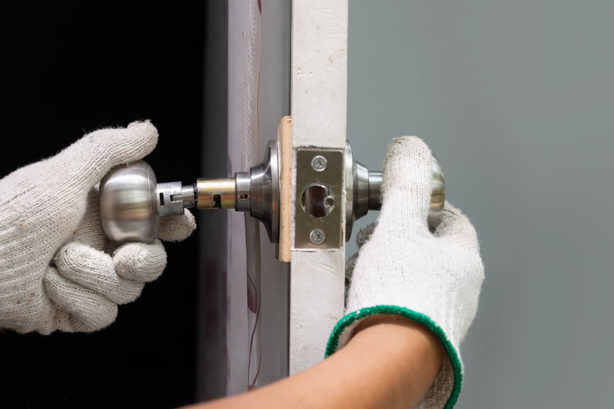 The photo tells about a man's hand with gloves repairing the door knob indicating to skills reduce reliance on expensive services can save money and can even turn into a way to make money.