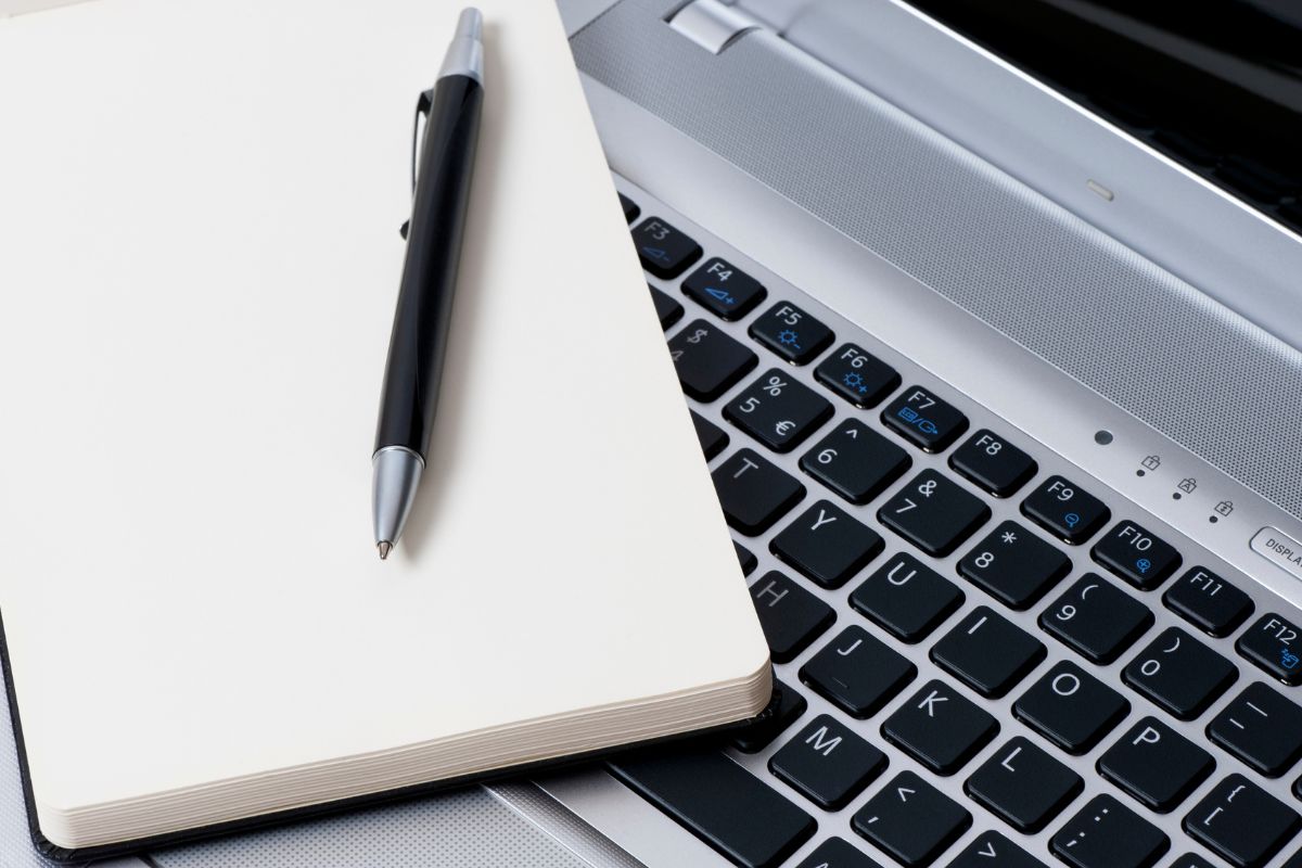 The picture shows a laptop, a pen, and a notebook which means studying and modeling successful millionaires and applying their strategies helps with the steps of your financial growth. 