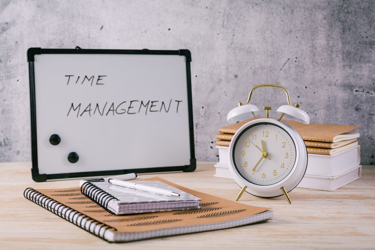 Photo of a clock and a board with time management written.