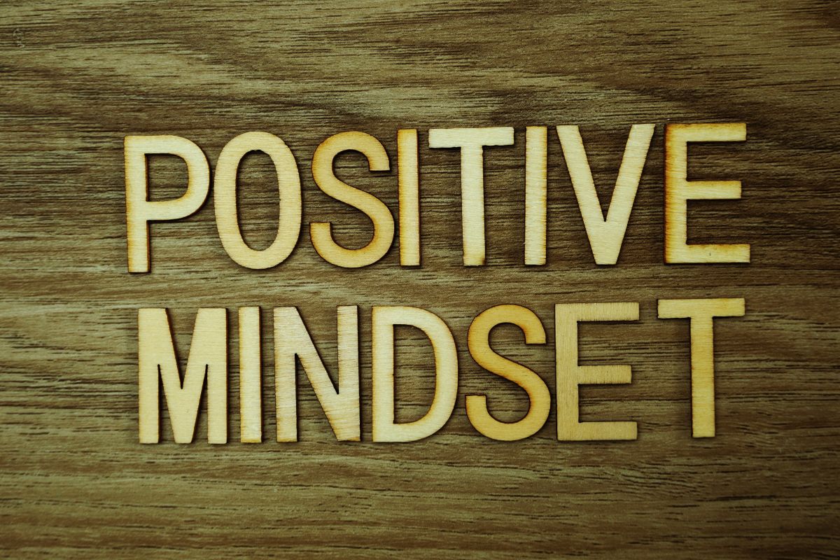The picture shows wooden letters on the table indicating that keeping a positive focused mindset helps you spot opportunities instead of excuses.