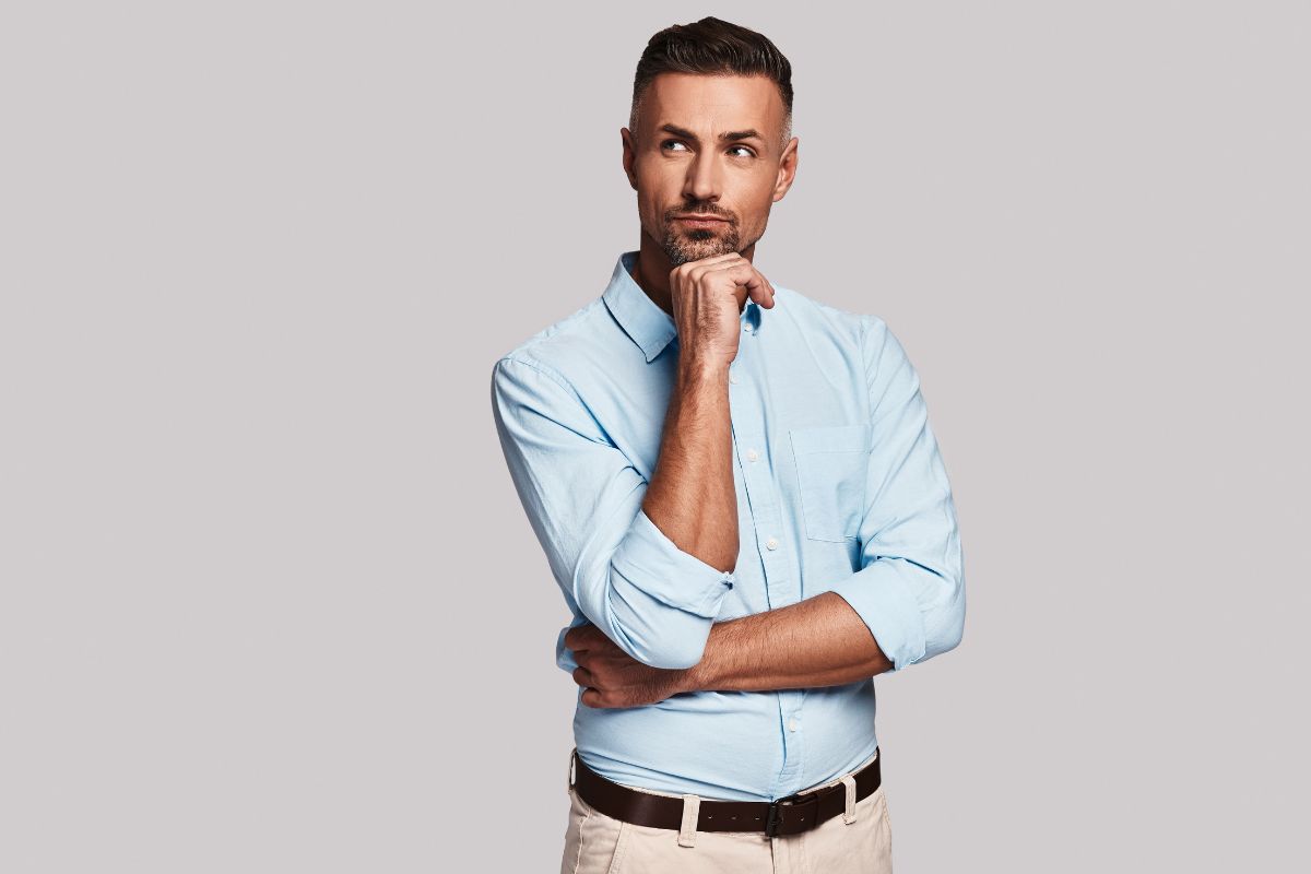 The photo tells about a man putting his hand on his chin and wondering indicating to always ask and finding ways to make things more efficient creates more money.