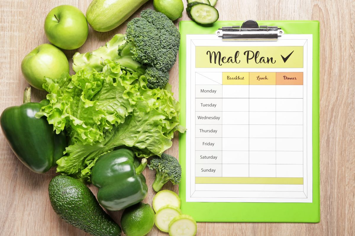 The image tells about fruits, vegetables, and a clipboard with a piece of paper and notes which means to plan meals based on what you already have helps use up what you have before it goes bad.