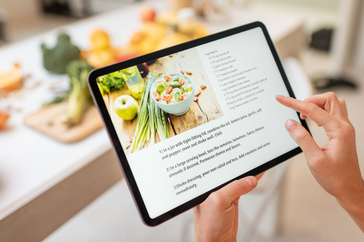 The picture of a woman's hand searching online recipes.