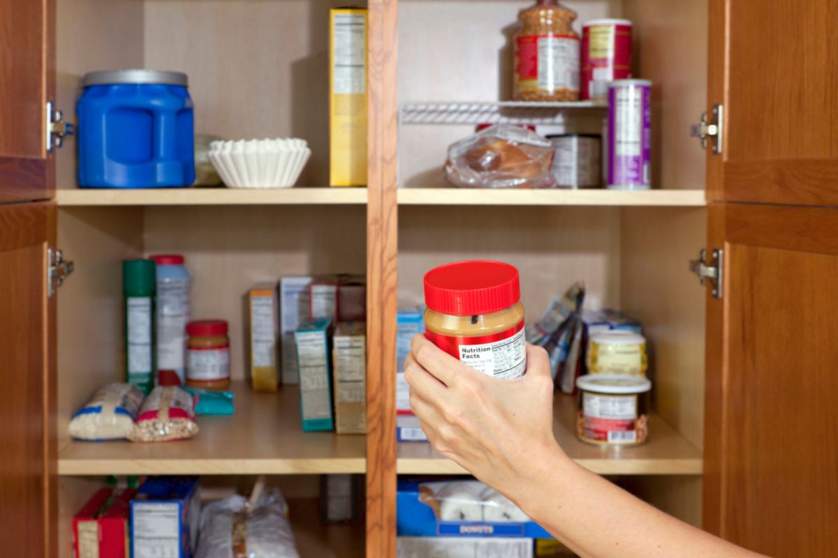 An image of a woman's hand organizing the pantry.