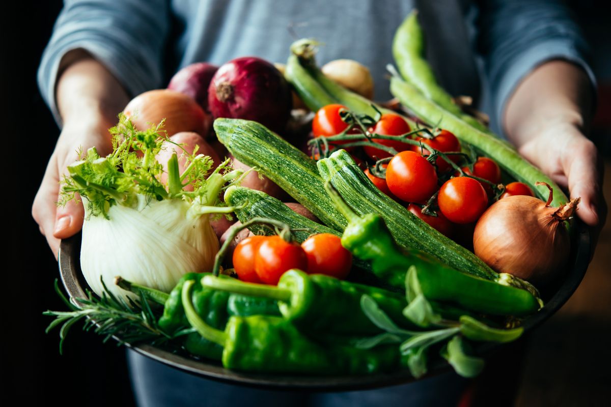 Picture of a woman holding a basket of vegetables.