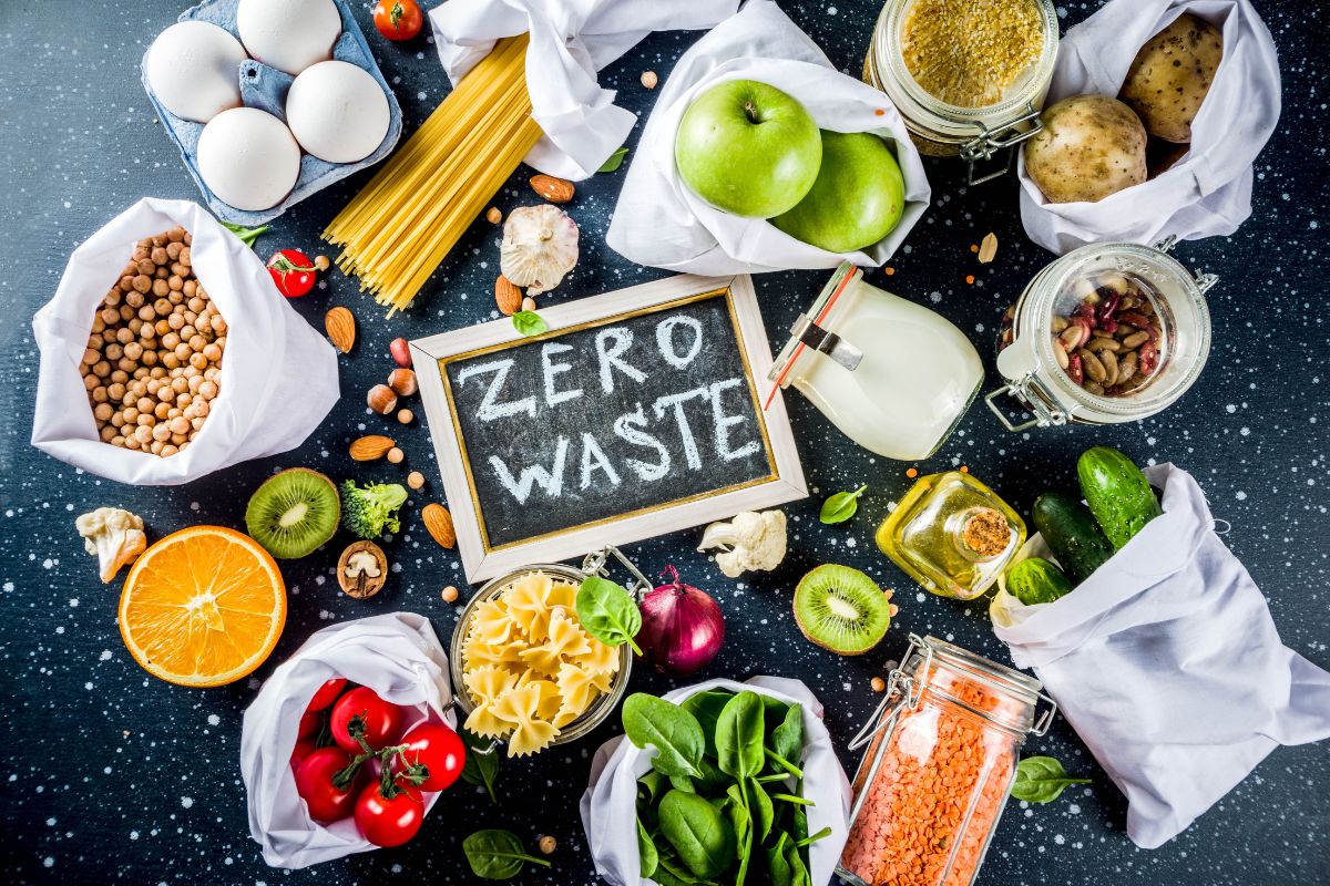 The photo shows fruits, vegetables, pasta and a board with notes referring to setting up a no-waste zone is a simple trick to cut down on spoiled food and save money.