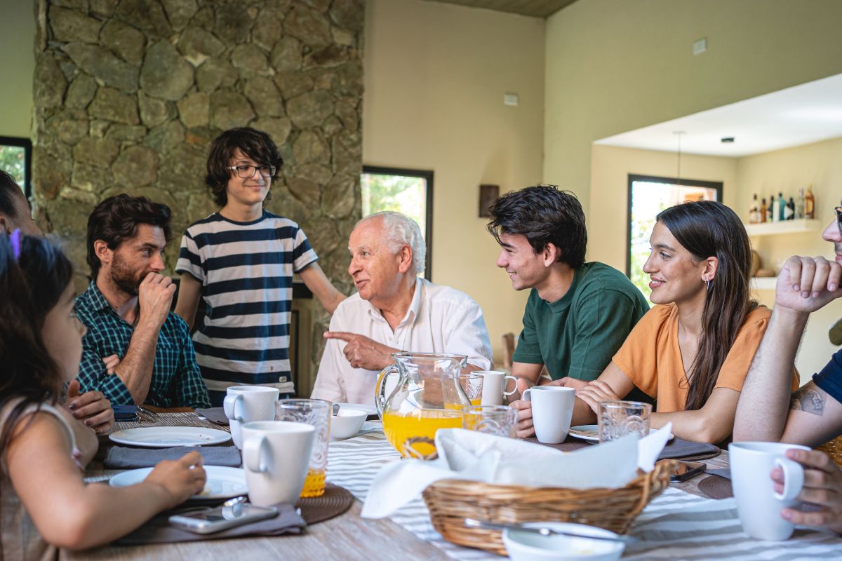 The image shows a group of family talking over the meal.