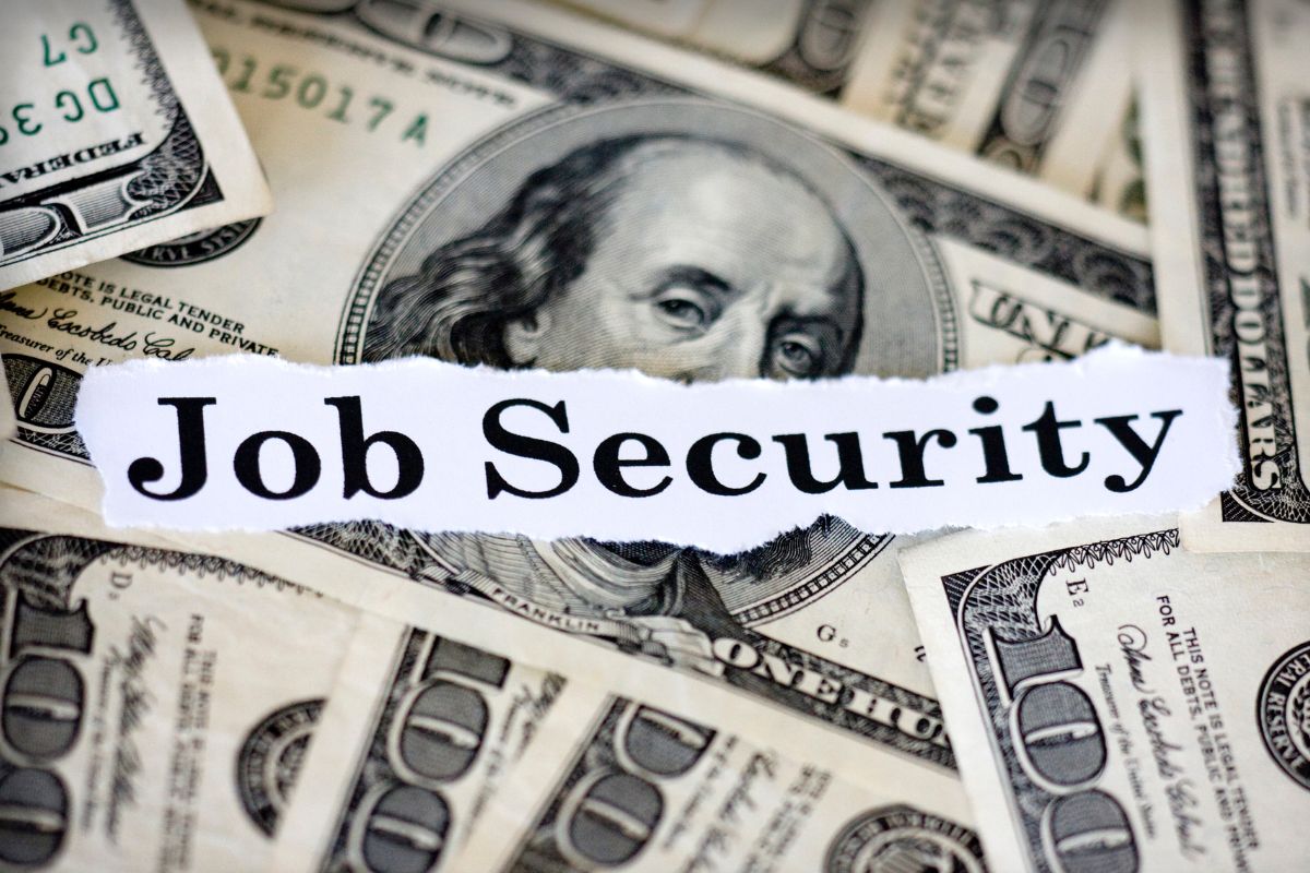Photo of money and a paper with job security wording.