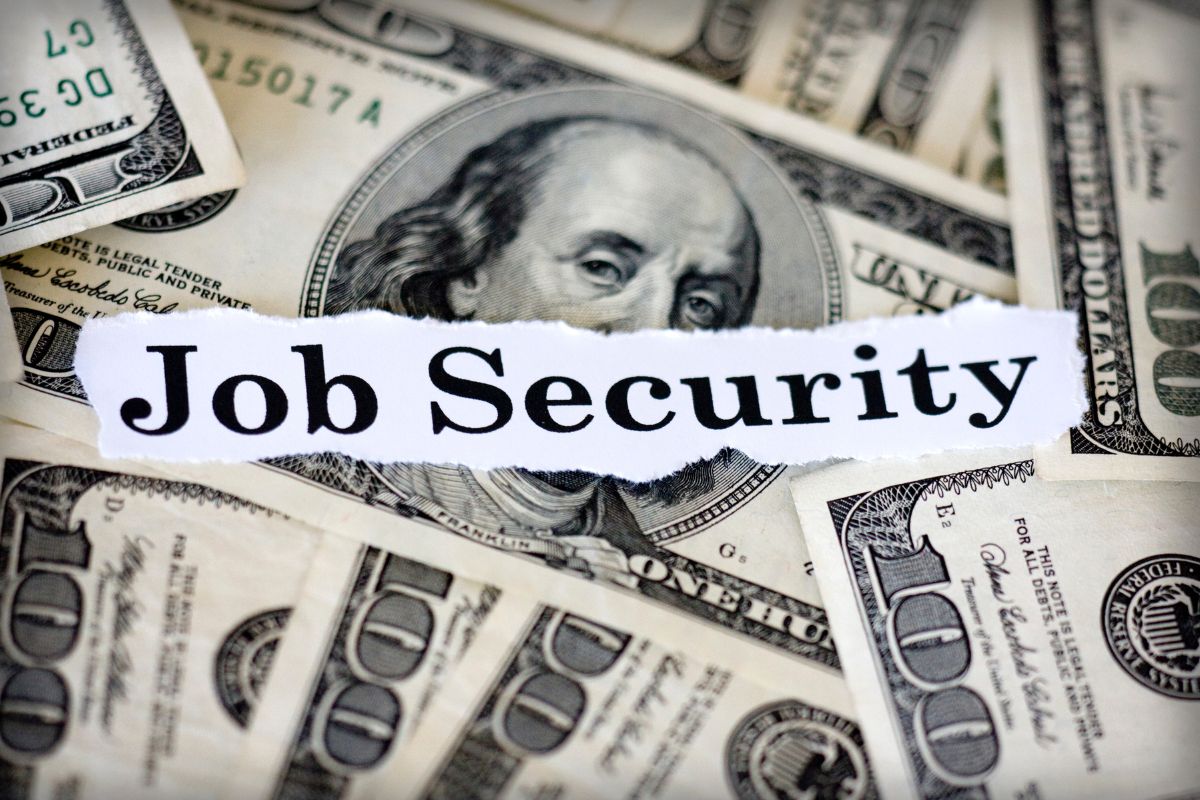 The image tells about dollar bills and a piece of paper with notes referring to enhanced job security makes you a stronger candidate for promotions and long-term stability. 