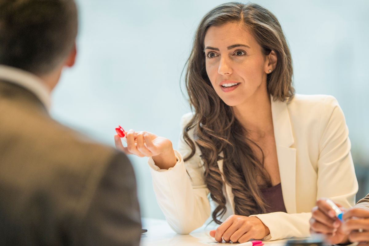 The picture shows a girl in a formal dress talking to a man in a suit referring to enables negotiations for higher salaries making it easier to ask for and receive higher compensation.
