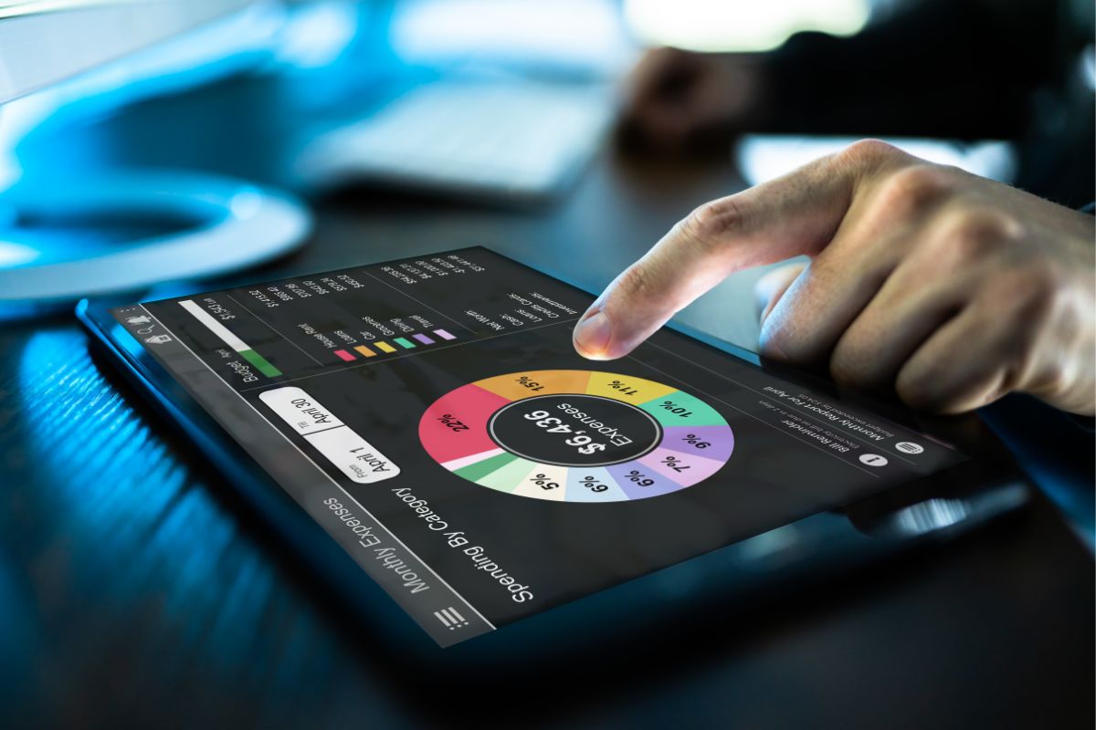 The picture of a man's hand using a budgeting app.