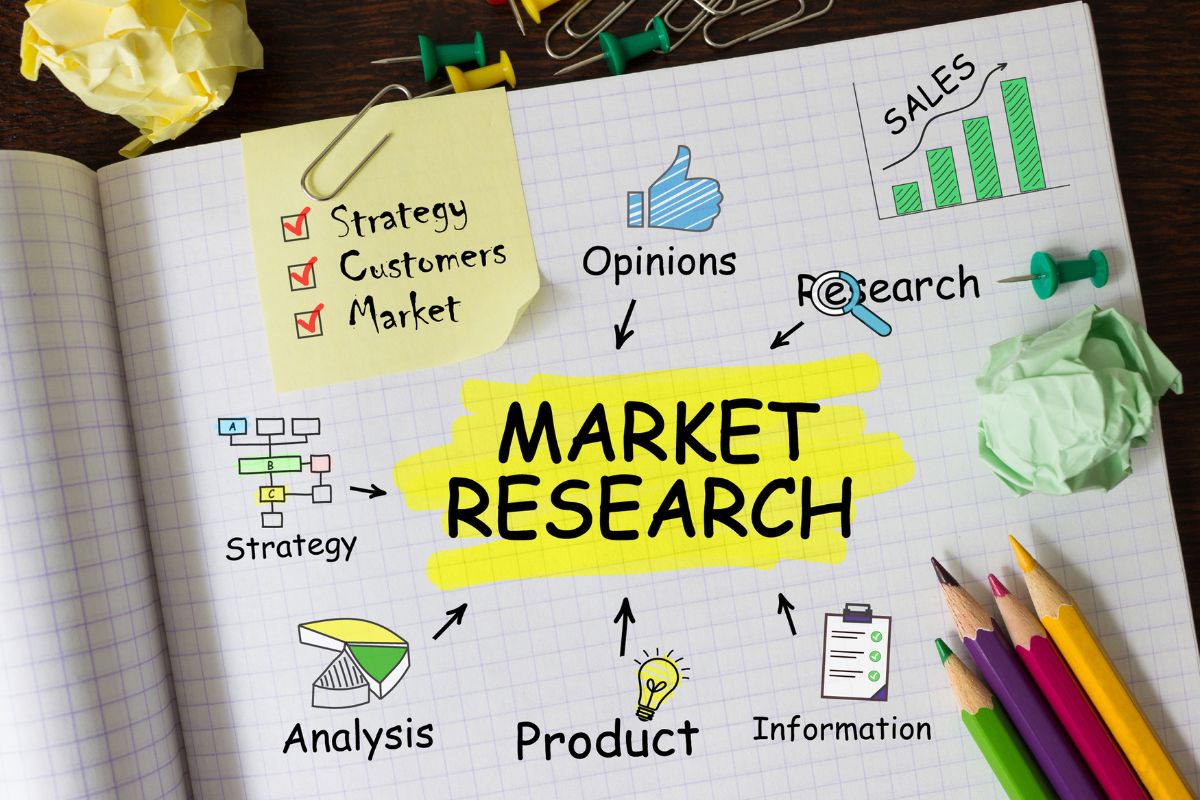The photo shows pins, clips, colored pens, and a notebook with notes and illustrations indicating that skills help in identifying and capitalizing on market trends can lead to higher earnings and smarter financial decisions.