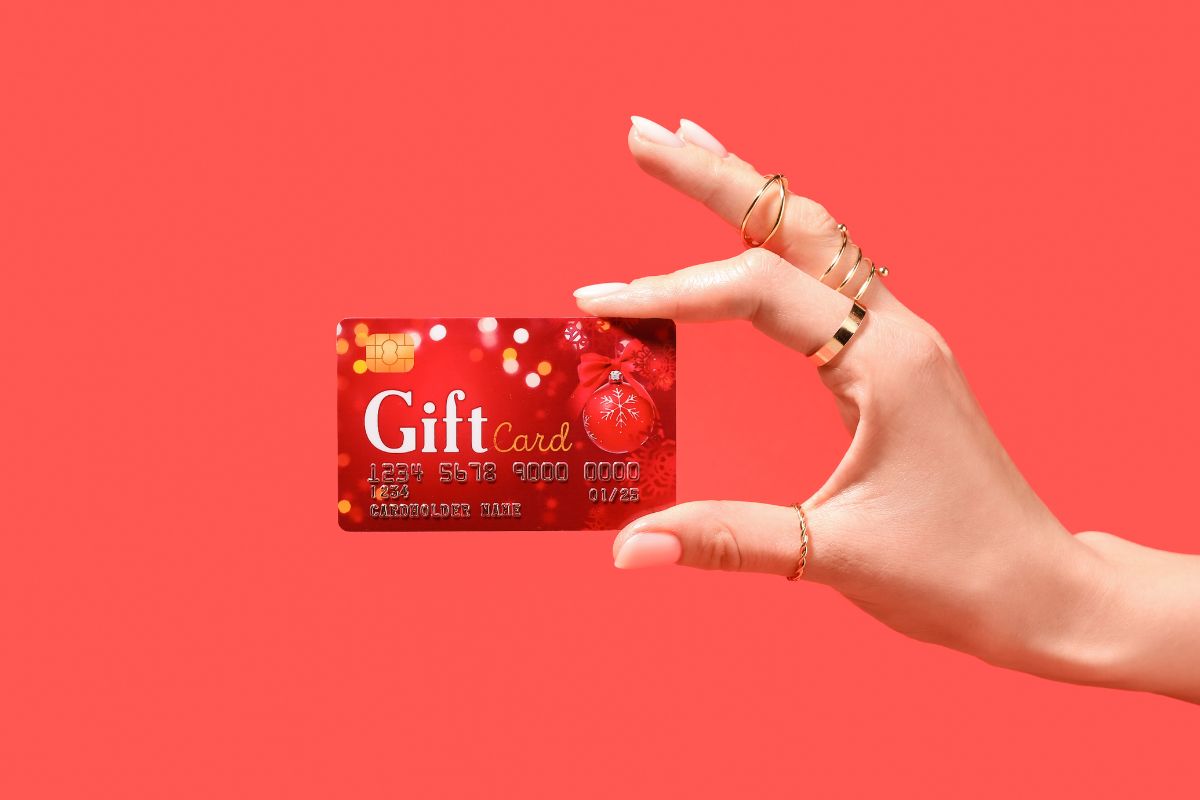 The photo shows a girl's hand holding a card with notes and numbers which refers to buying discounted gift cards is an easy way to stretch your money further.