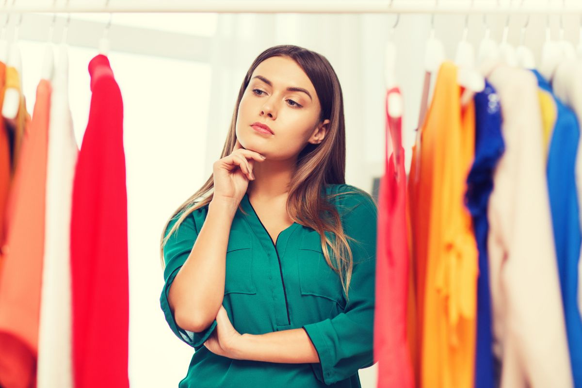 An image of a woman thinking while buying clothes.