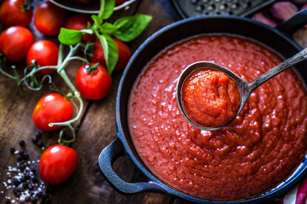 The picture shows tomatoes and a pot with sauce indicating to repurpose food before it spoils to turn leftovers into new meals instead of waste.