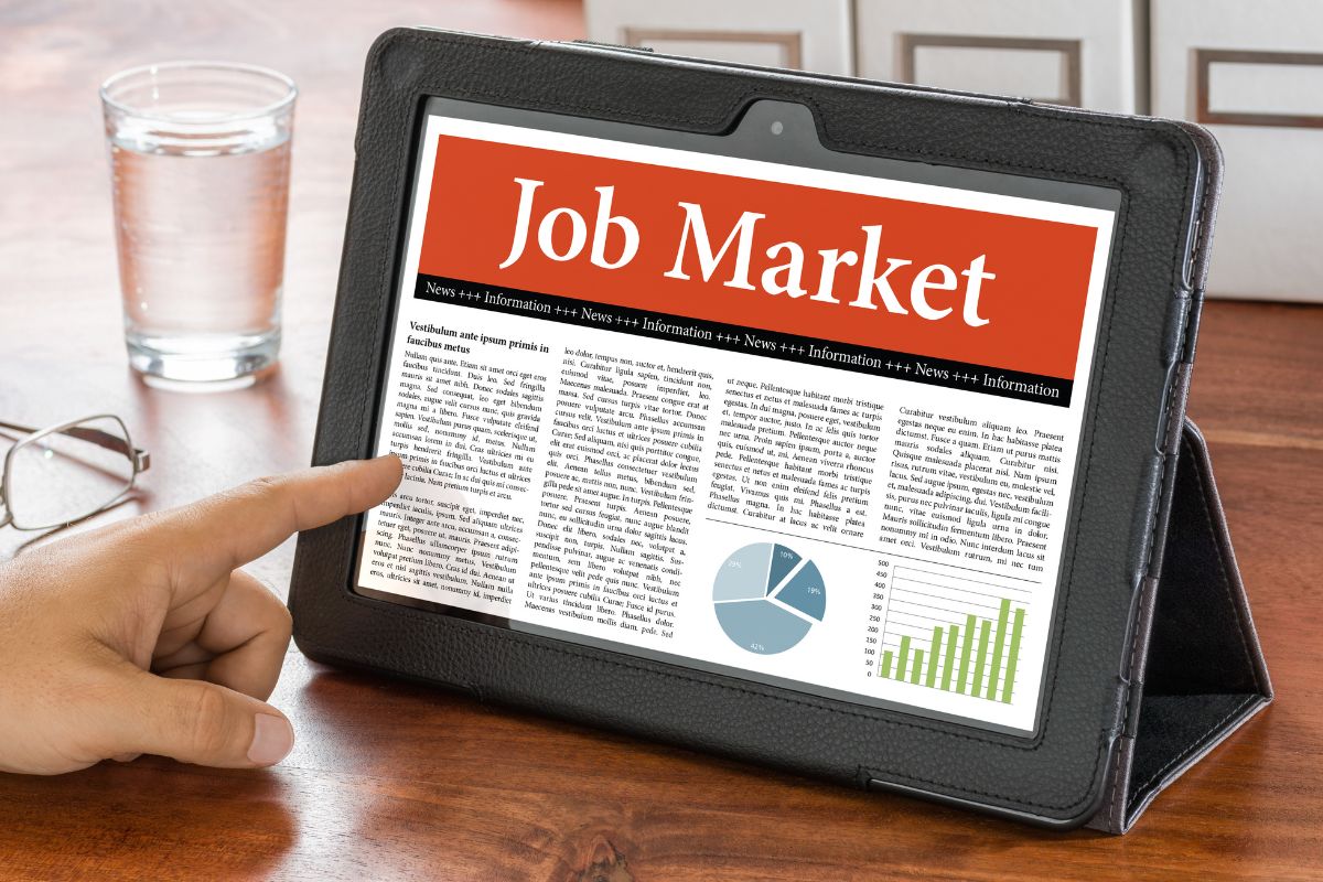 The picture tells about a glass of water, an eyeglass, and a man's hand pointing at the tablet with a screen display referring to enhances adaptability in an ever-changing job market makes it easier to adapt and stay employed.