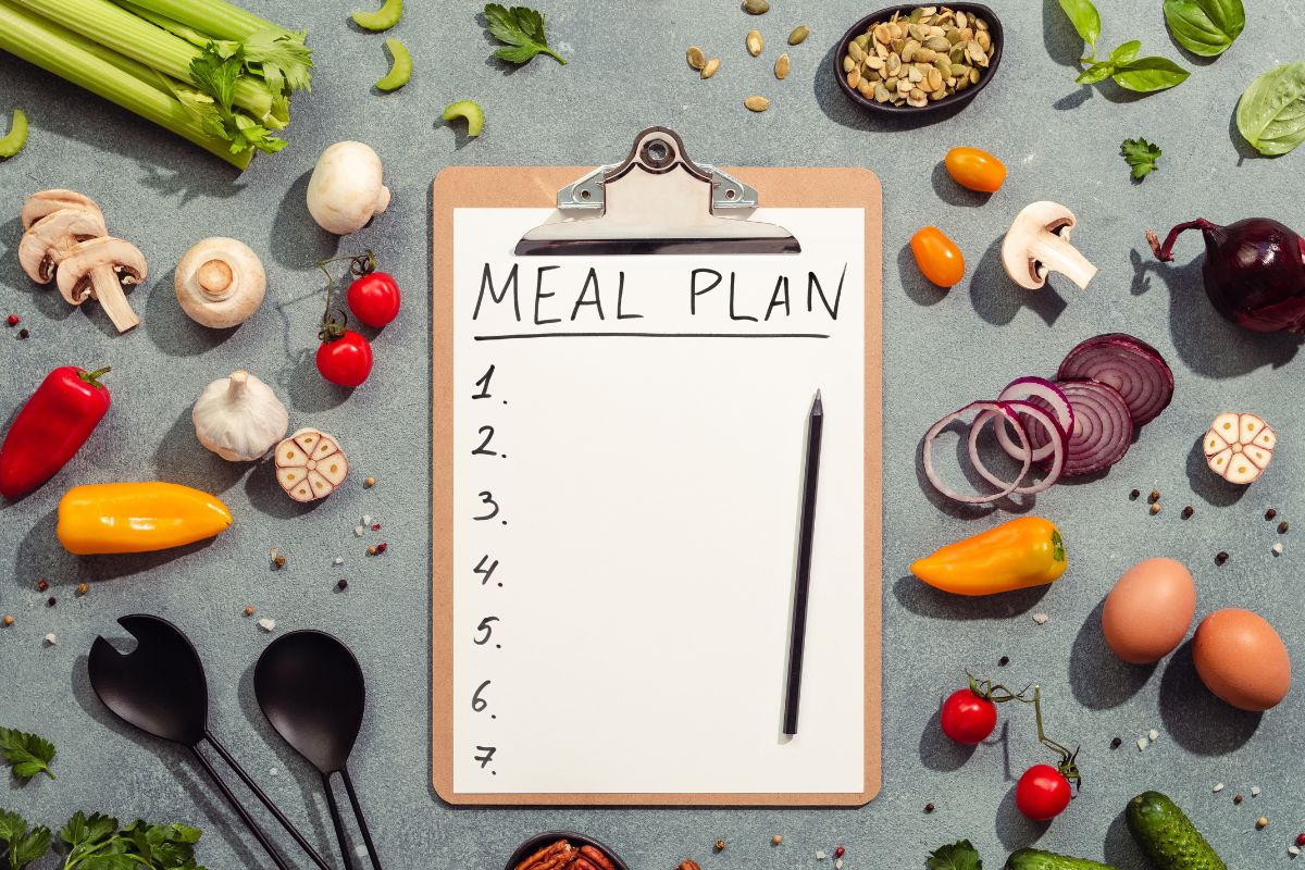 The picture shows ingredients and a paper with a meal plan list.