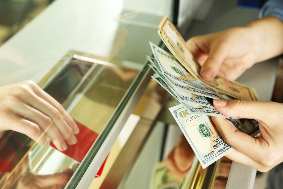Image of a woman's hand paying in cash.