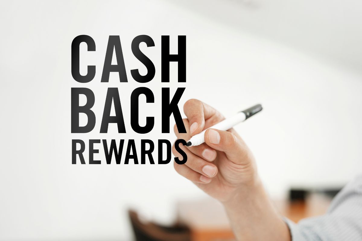 The photo shows a man's hand holding a marker and writing on the screen which refers to using cash-back and rewards apps and putting any rewards straight into savings.