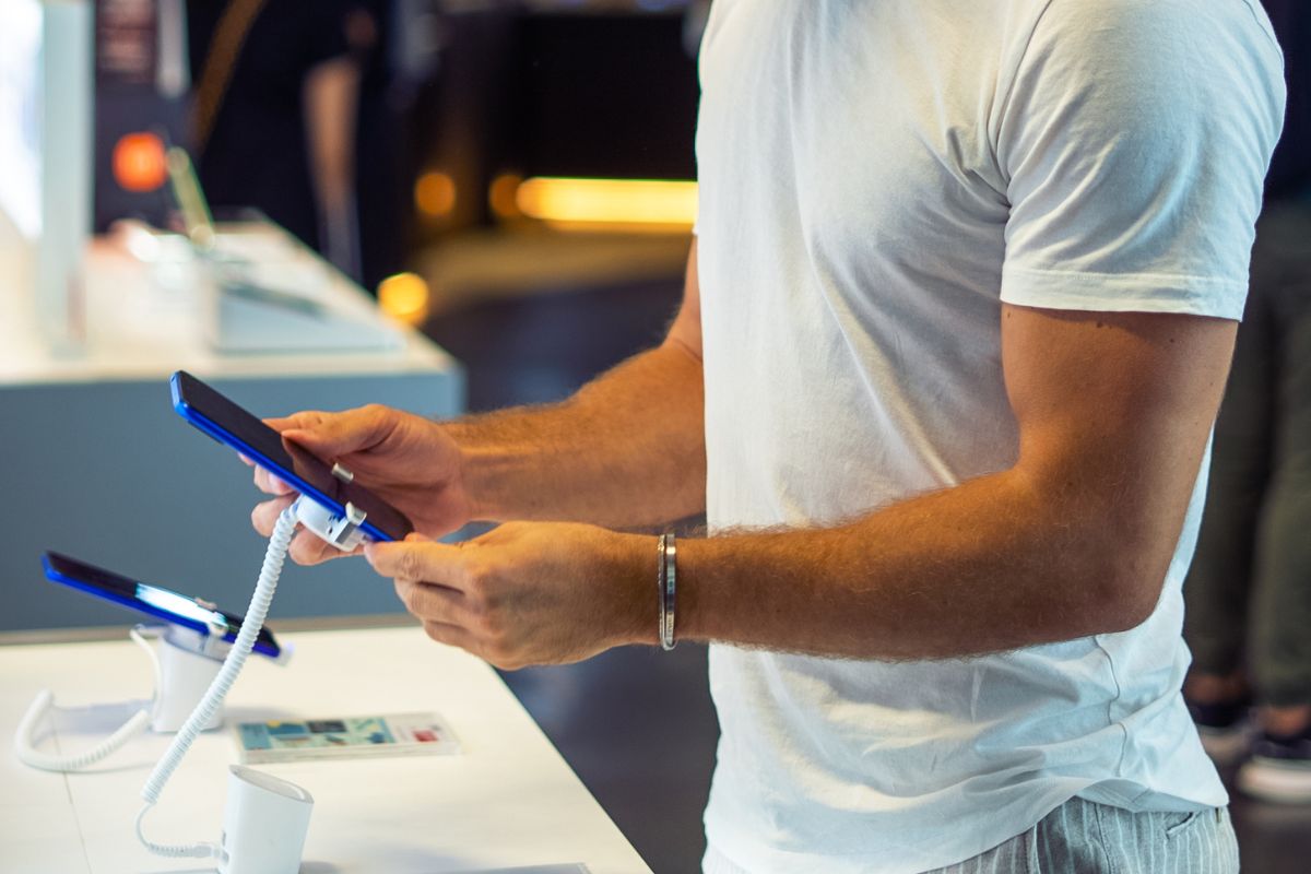 The photo shows a man checking a new phone.

