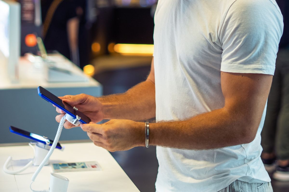 The image of a man checking on the phone displays at the store which refers to delaying big purchases can help you decide if it's really worth it.